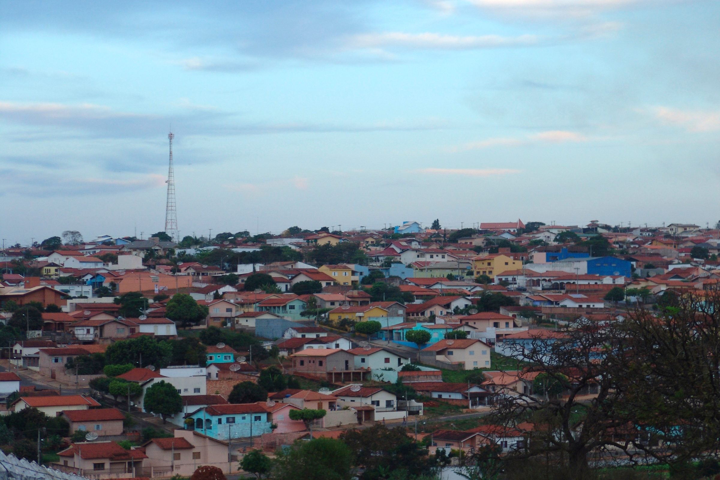 Vista da cidade de Itaí, com casas coloridas cobrindo a colina sob um céu de fim de tarde