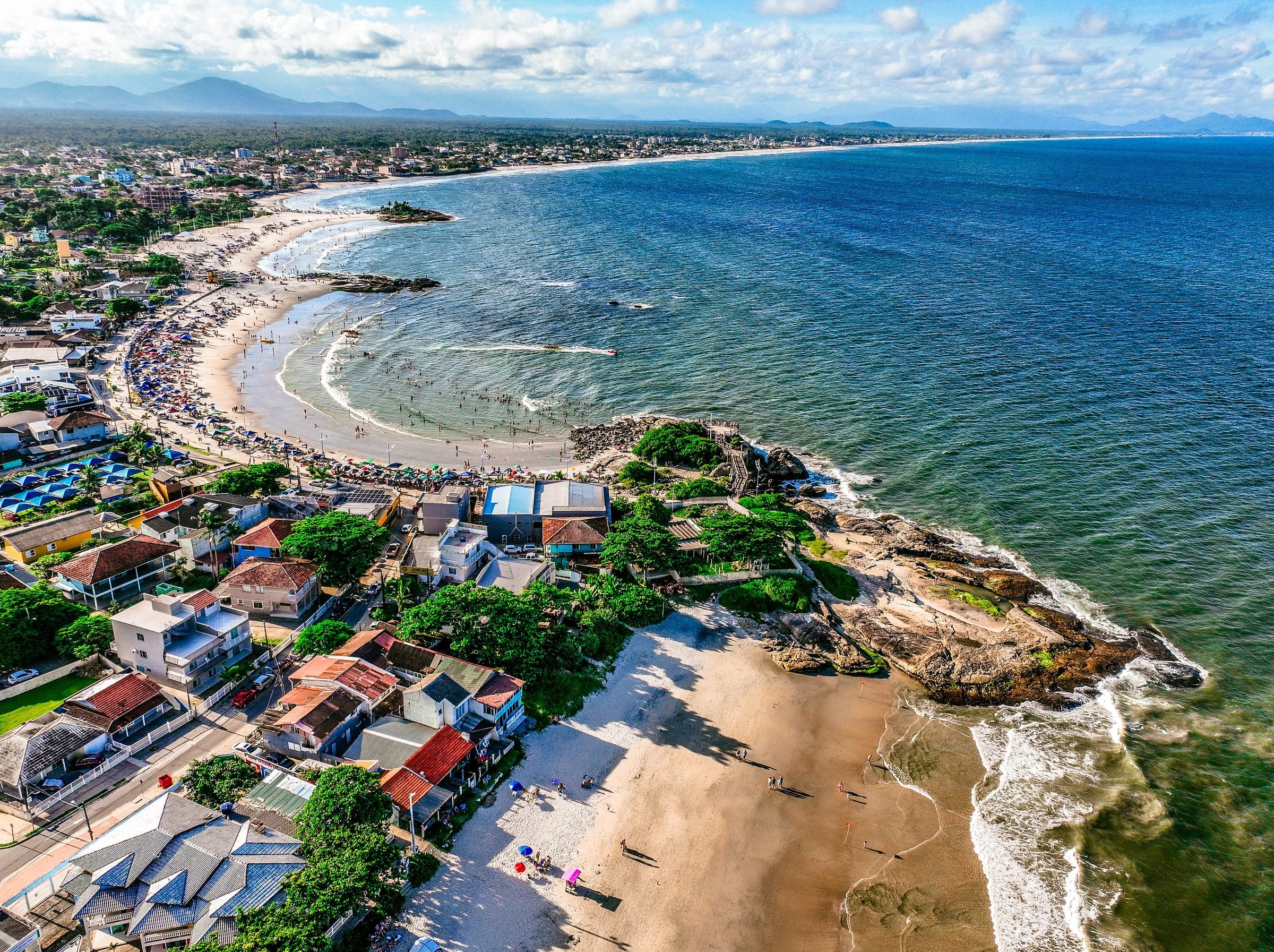 Vista aérea da orla de Itapoá, com as praias da Primeira, Segunda e Terceira Pedra, as casas à beira-mar e a serra ao fundo