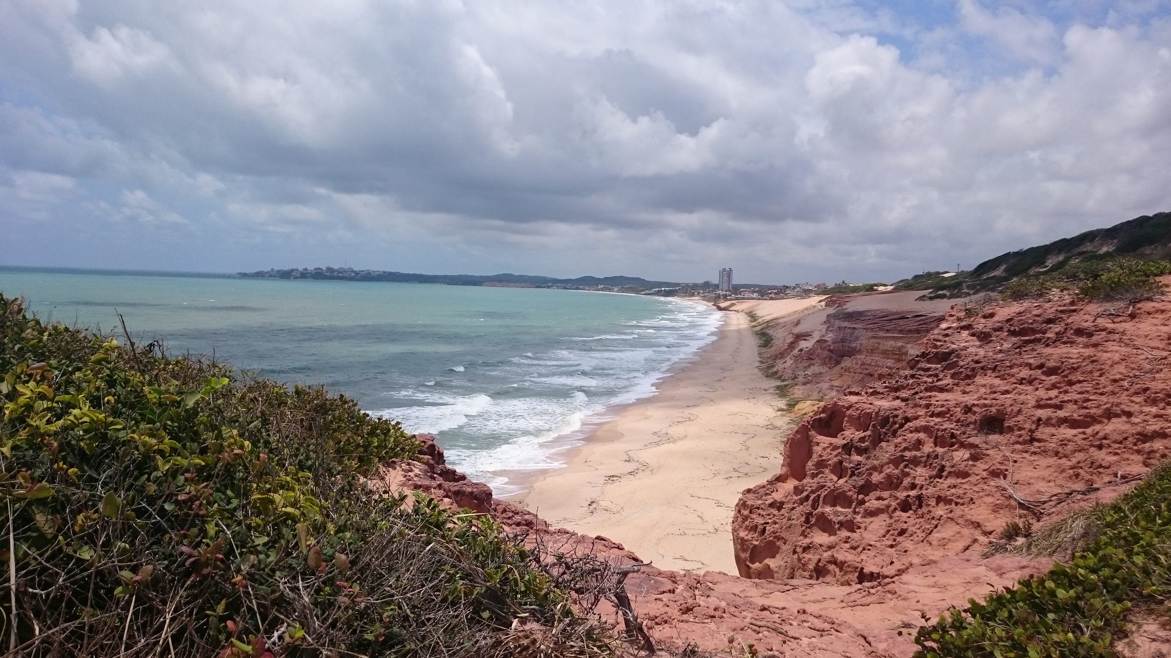 Falésias avermelhadas e a Praia de Cotovelo, no litoral de Parnamirim, vistas do alto da Barreira do Inferno