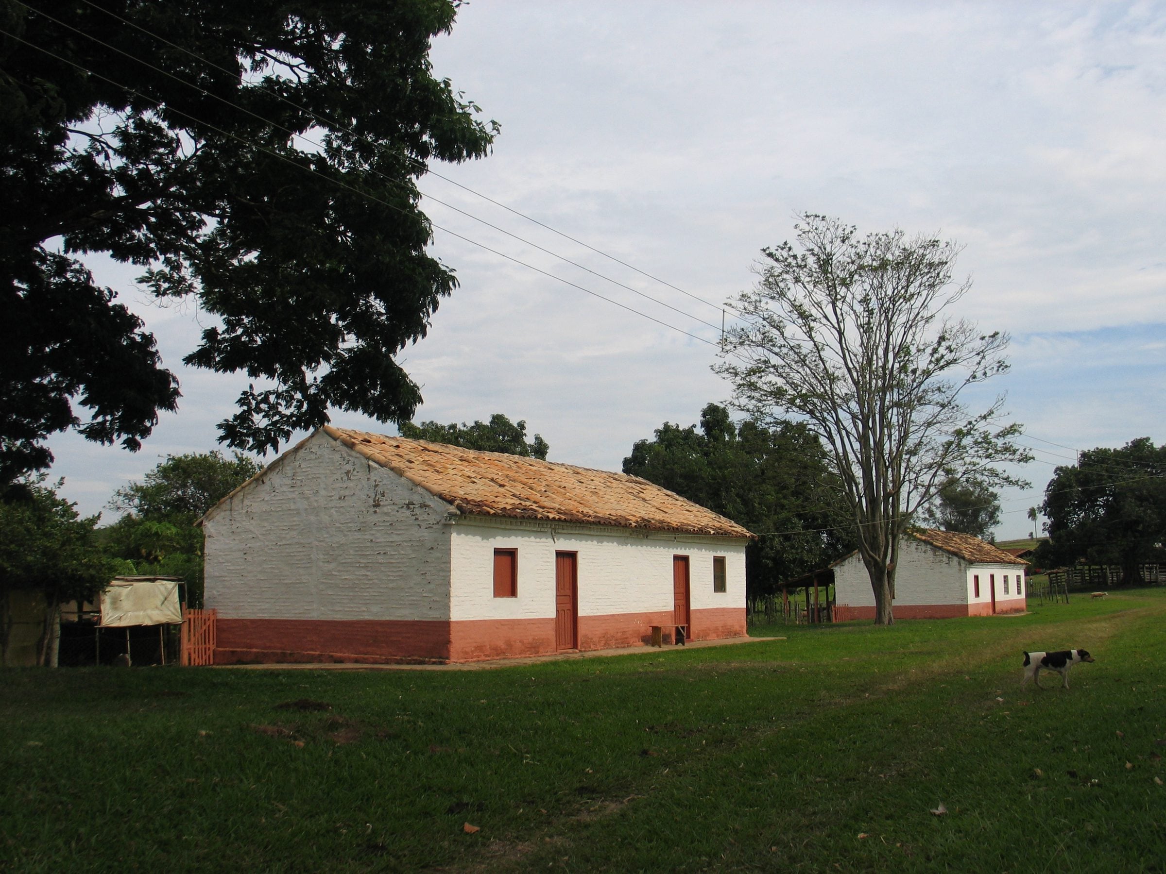 Casas caiadas de branco da histórica Fazenda do Engenho, na zona rural de Pirajuí, entre árvores e gramado
