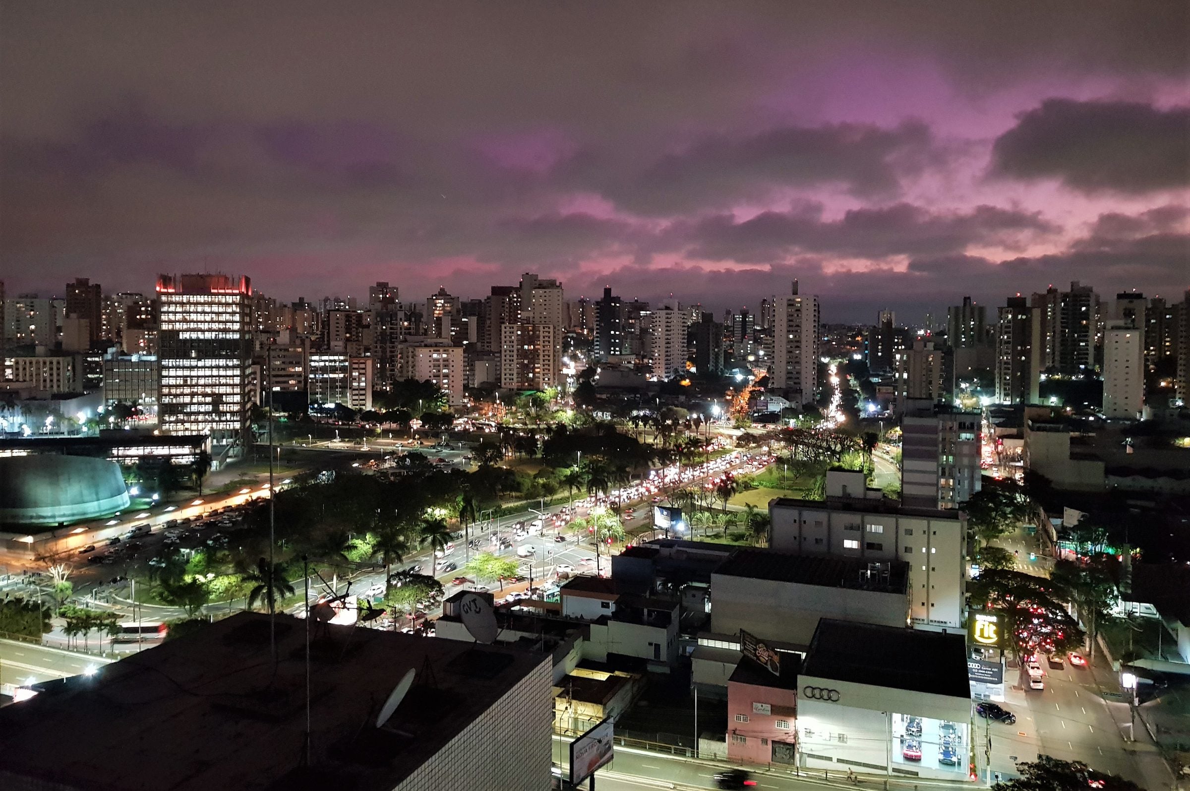 Vista noturna do centro de Santo André, com prédios iluminados e avenidas arborizadas