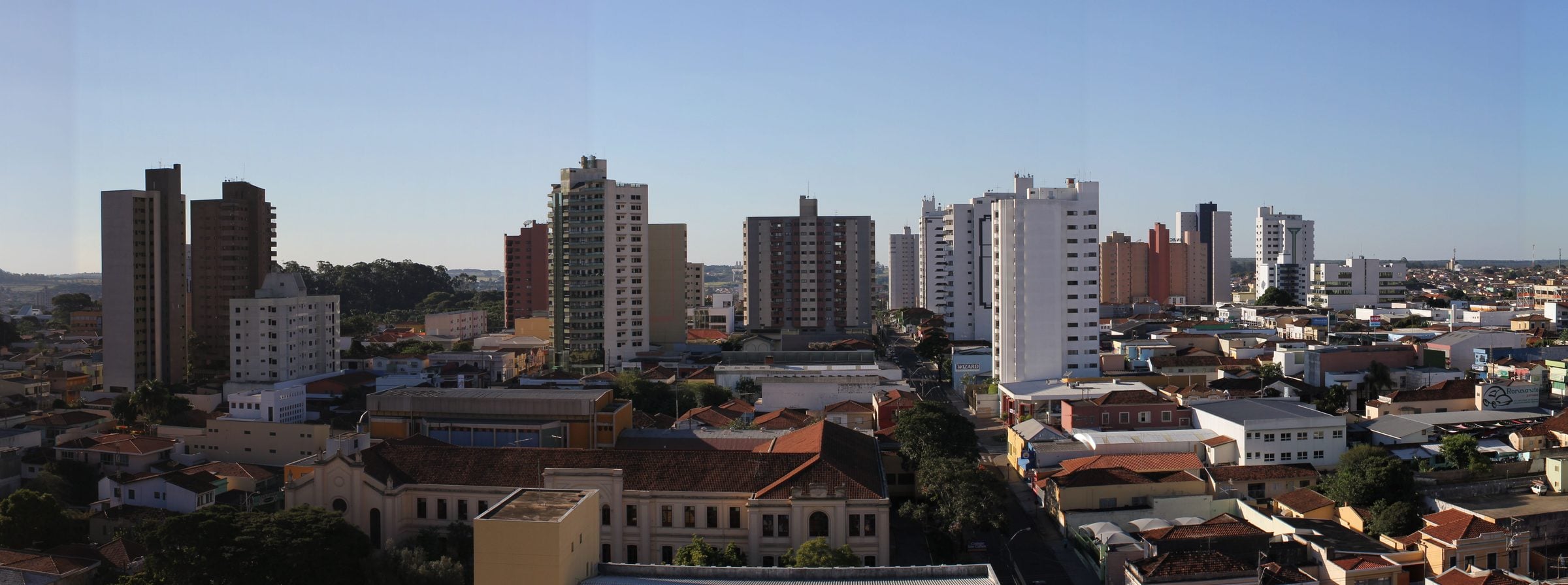 Vista panorâmica do centro de São Carlos, com prédios altos e casarios sob céu azul