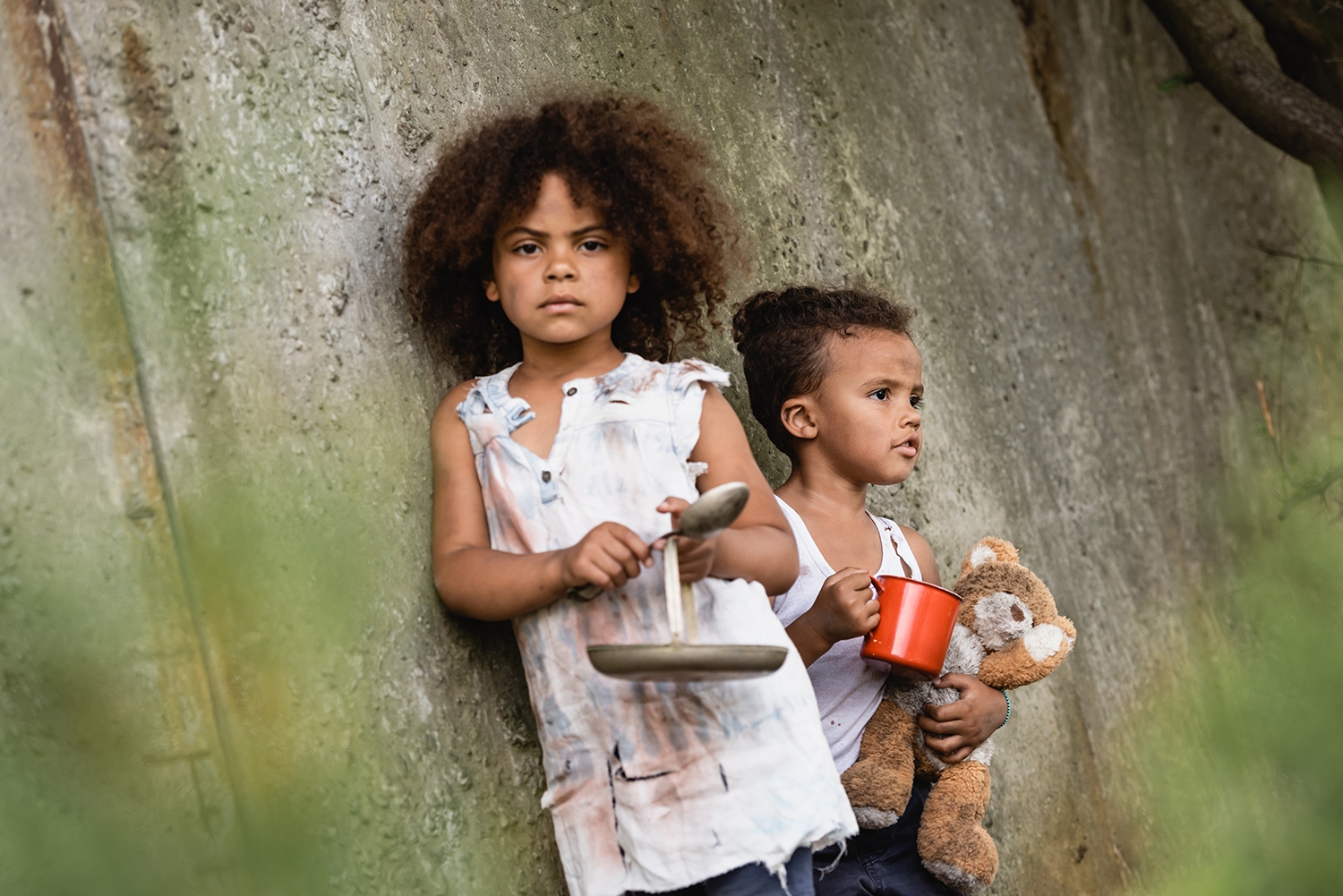 Duas crianças junto a uma parede, em fotografia ilustrativa do projeto